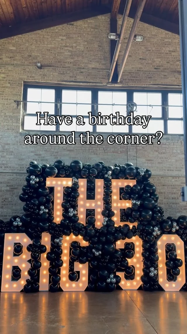 The Big 30 illuminated marquee letters and numbers surrounded by dark balloons